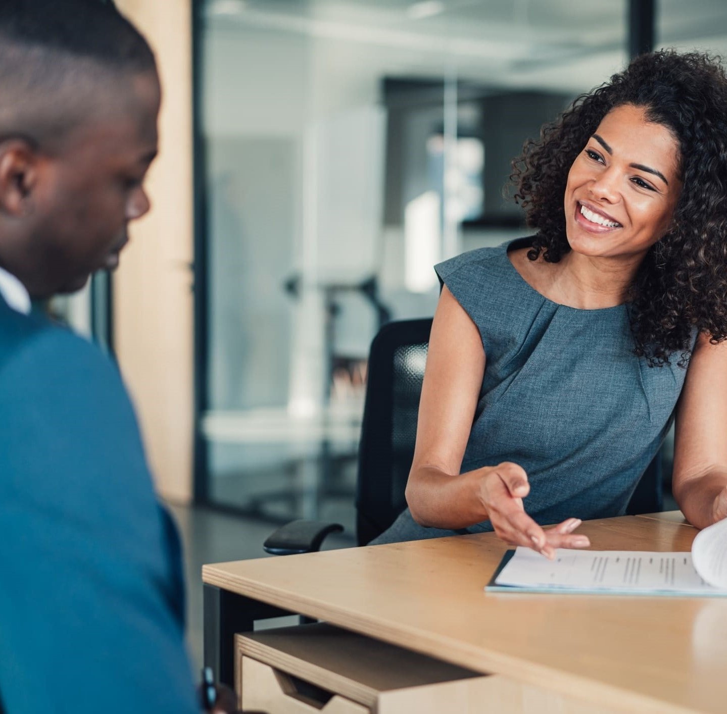 Jeune femme assise dans son bureau en rendez-vous avec un client